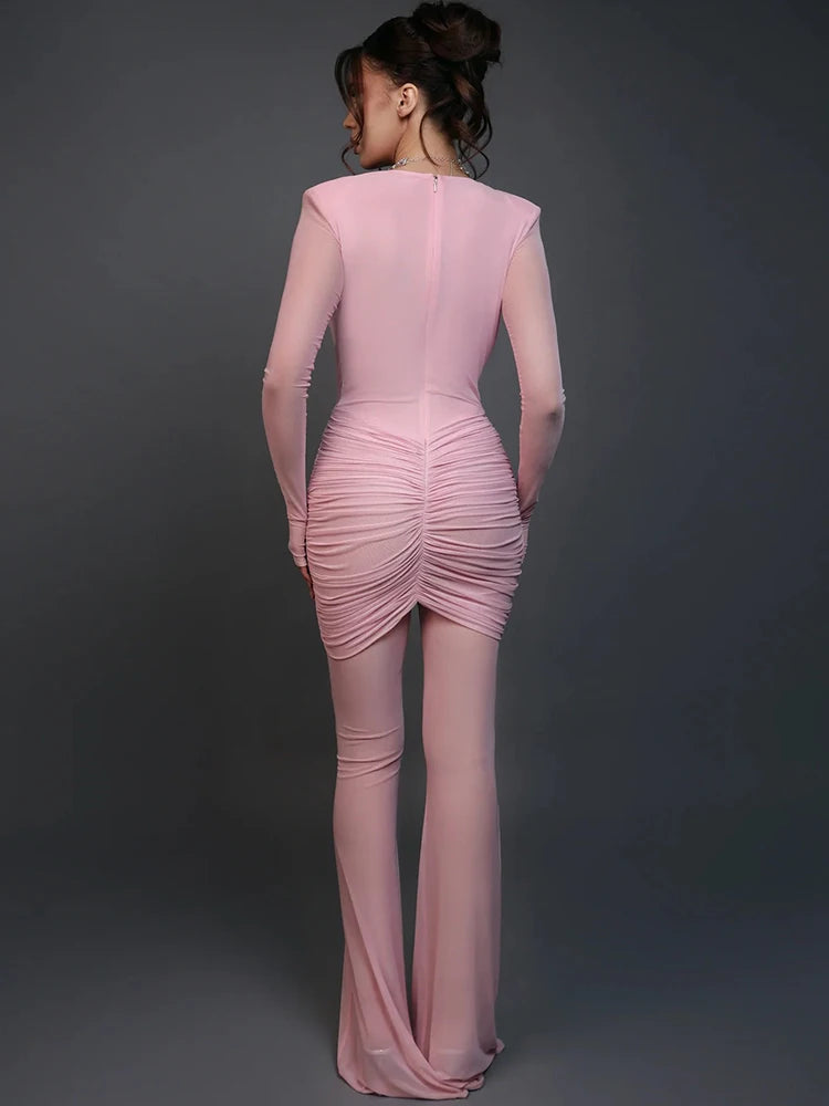 Pink dress with ruched detailing on a dark gray background