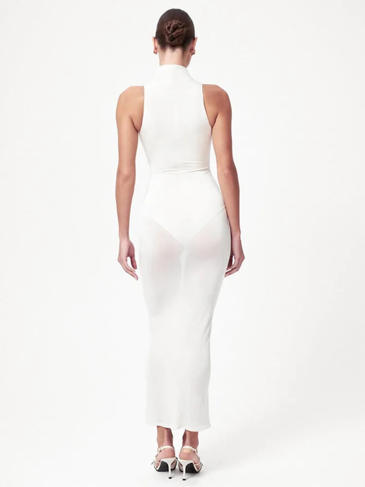 Woman wearing a white halter neck dress on a white background