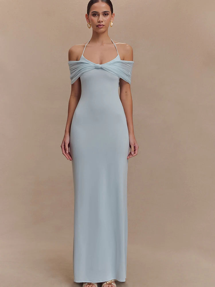 Woman wearing a light blue off-shoulder gown against a beige background