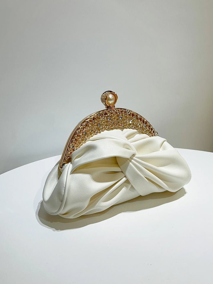 White clutch with gold frame on a white surface