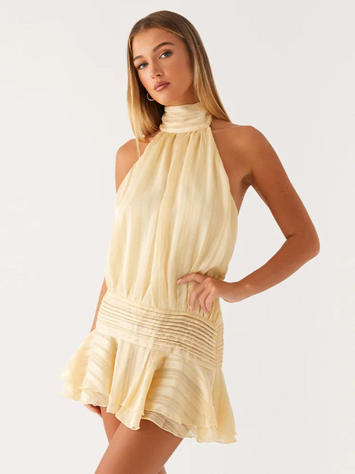 Woman wearing a beige halter neck dress on a white background