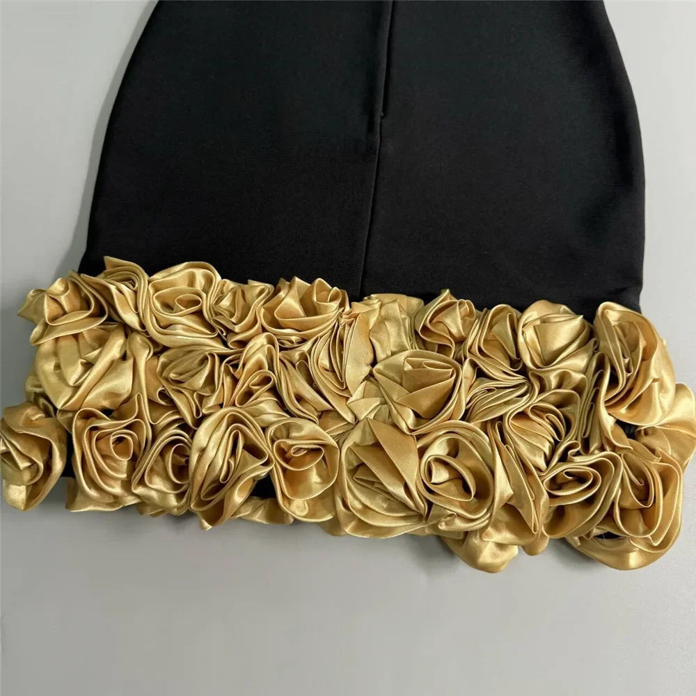 Black garment with gold floral detailing on a gray background