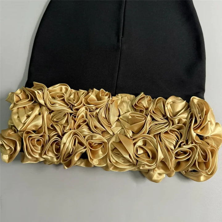 Black garment with gold floral detailing on a gray background