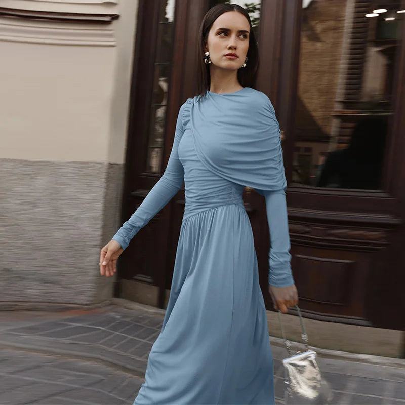 Woman in a blue dress walking on a street.