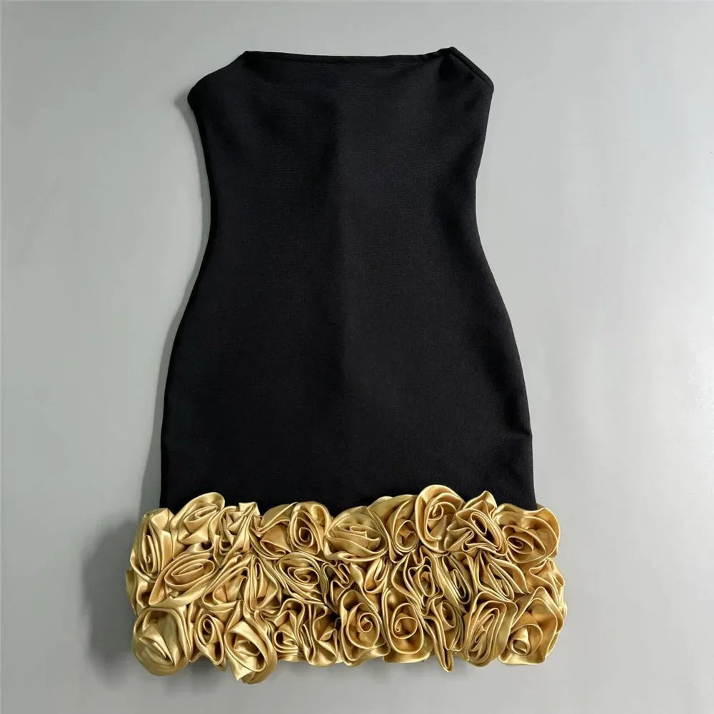 Black dress with gold floral hem on a gray background