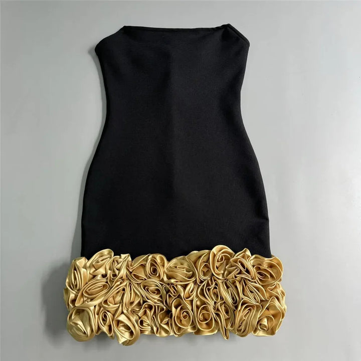 Black dress with gold floral hem on a gray background