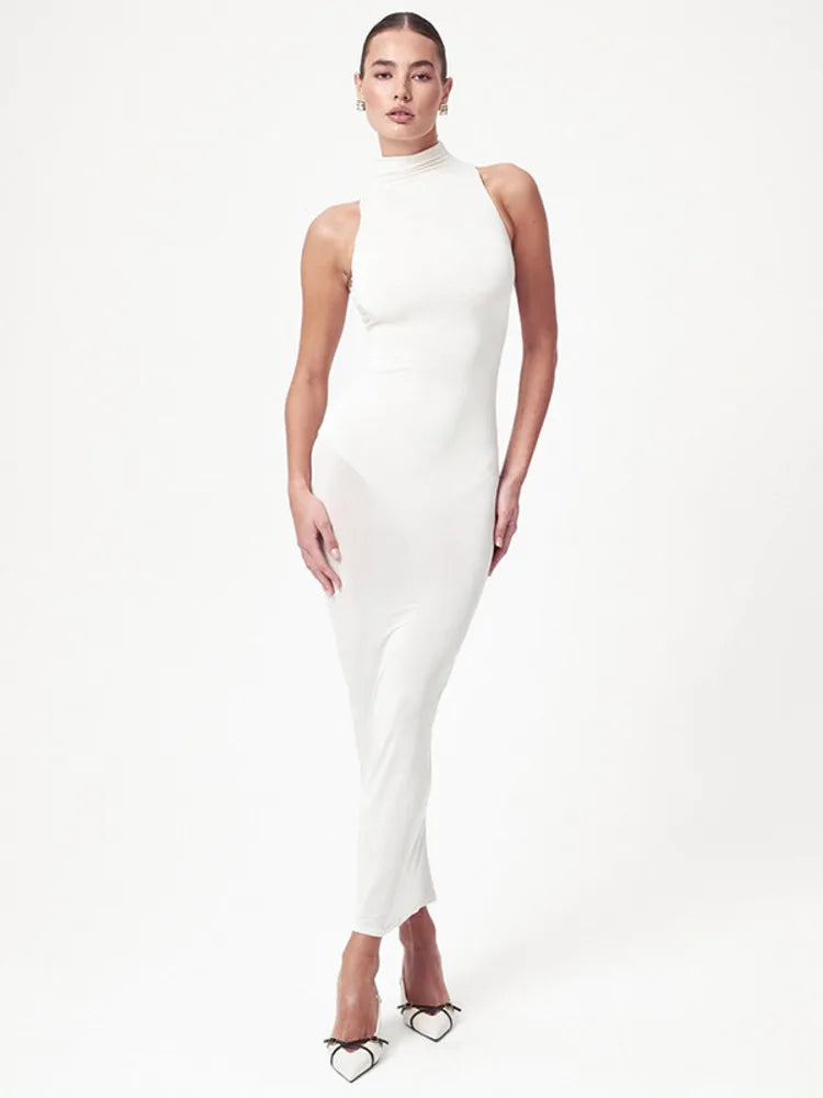 Woman wearing a white halter neck dress on a white background