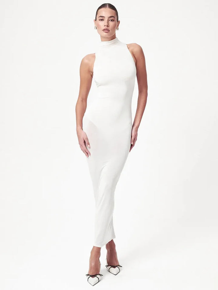 Woman wearing a white halter neck dress on a white background
