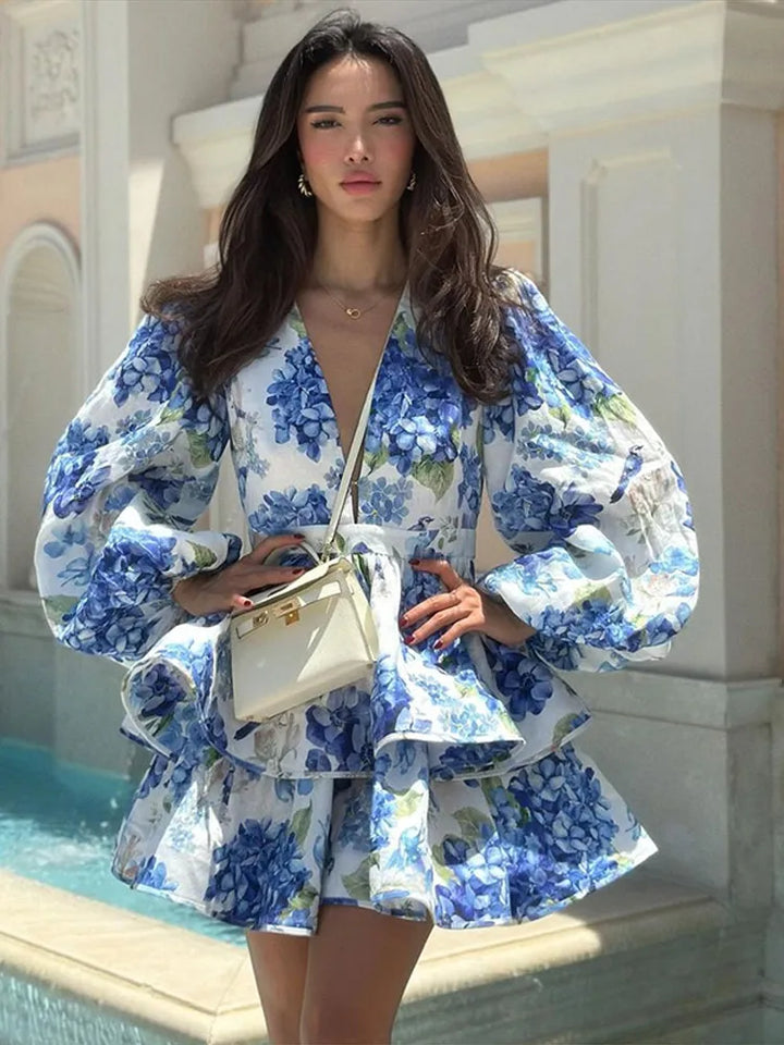 Woman in a blue floral dress standing by a pool