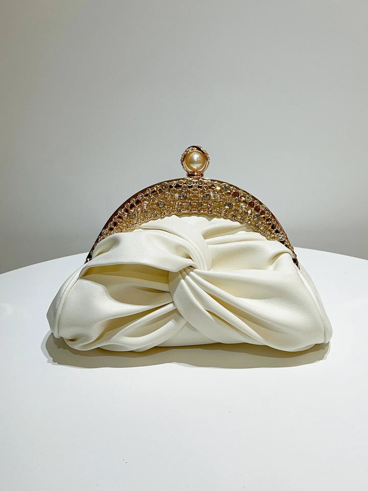 White clutch bag with a gold decorative frame on a white background