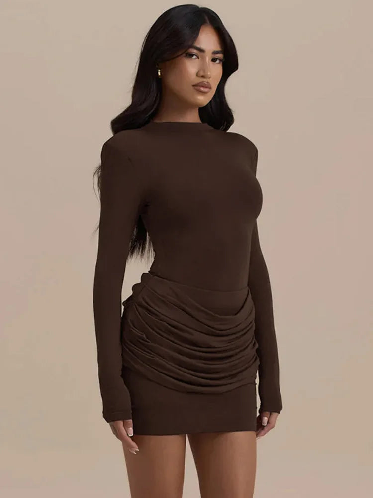 Woman wearing a brown long-sleeve dress against a beige background