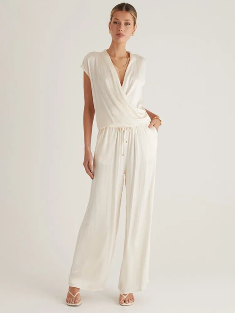 Woman wearing a white jumpsuit on a plain background