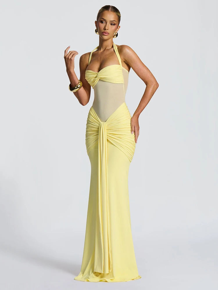 Woman wearing a yellow evening gown on a light gray background