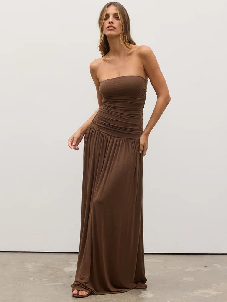 Woman wearing a brown strapless dress against a white background