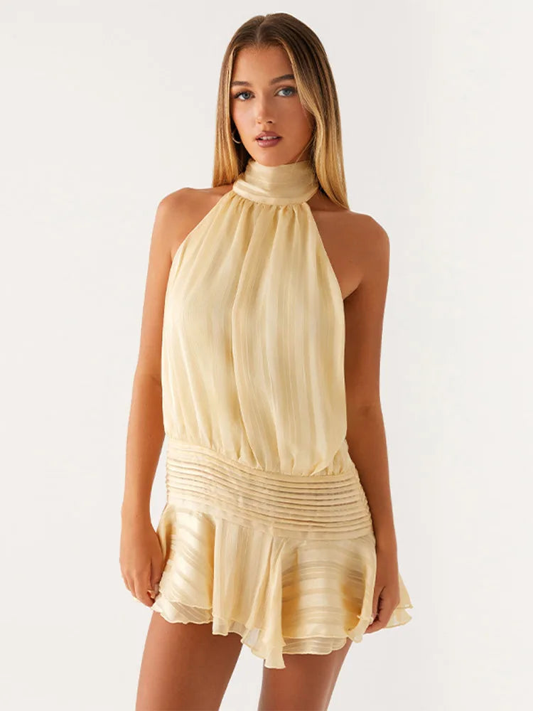 Woman wearing a beige halter neck dress on a white background