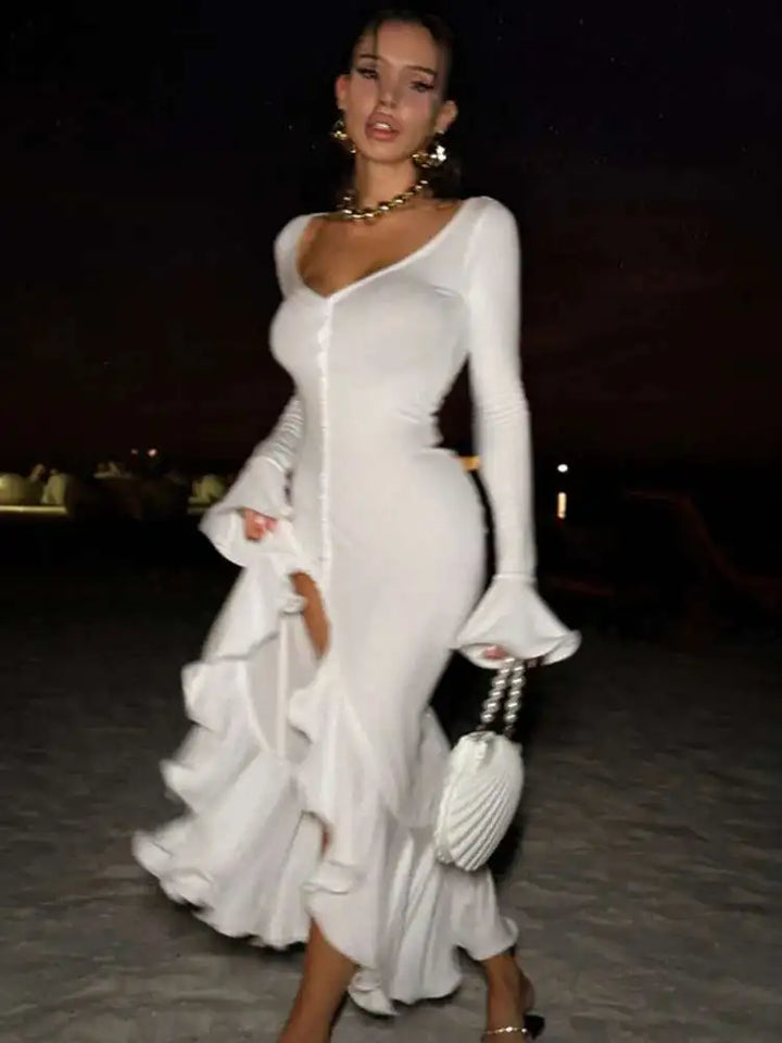 Woman in a white dress with a slit walking outdoors on a path.
