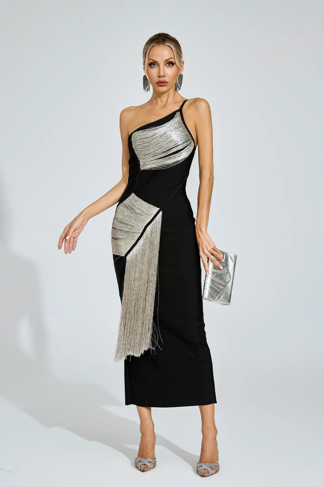 Woman wearing a black and silver one-shoulder dress on a white background