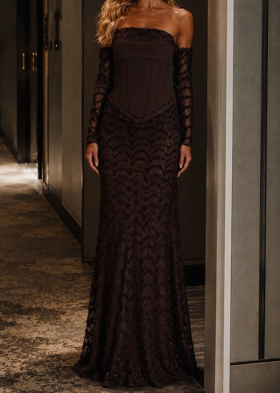 Woman wearing a dark lace evening gown in an indoor setting