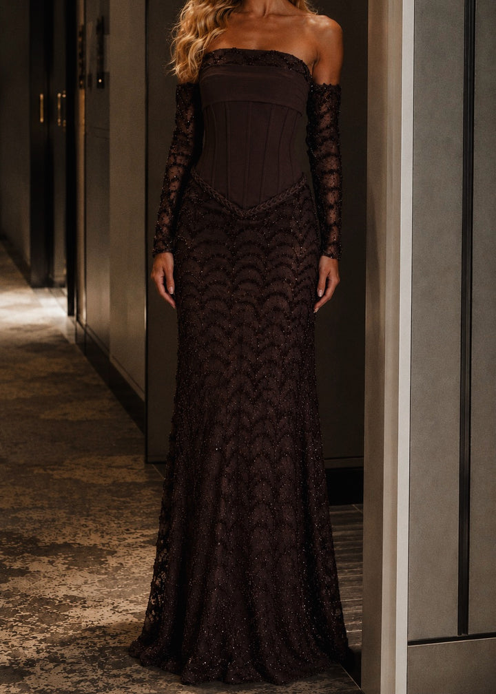 Woman wearing a dark lace evening gown in an indoor setting