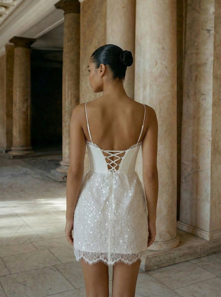 Woman in a white lace dress standing in an ancient temple setting