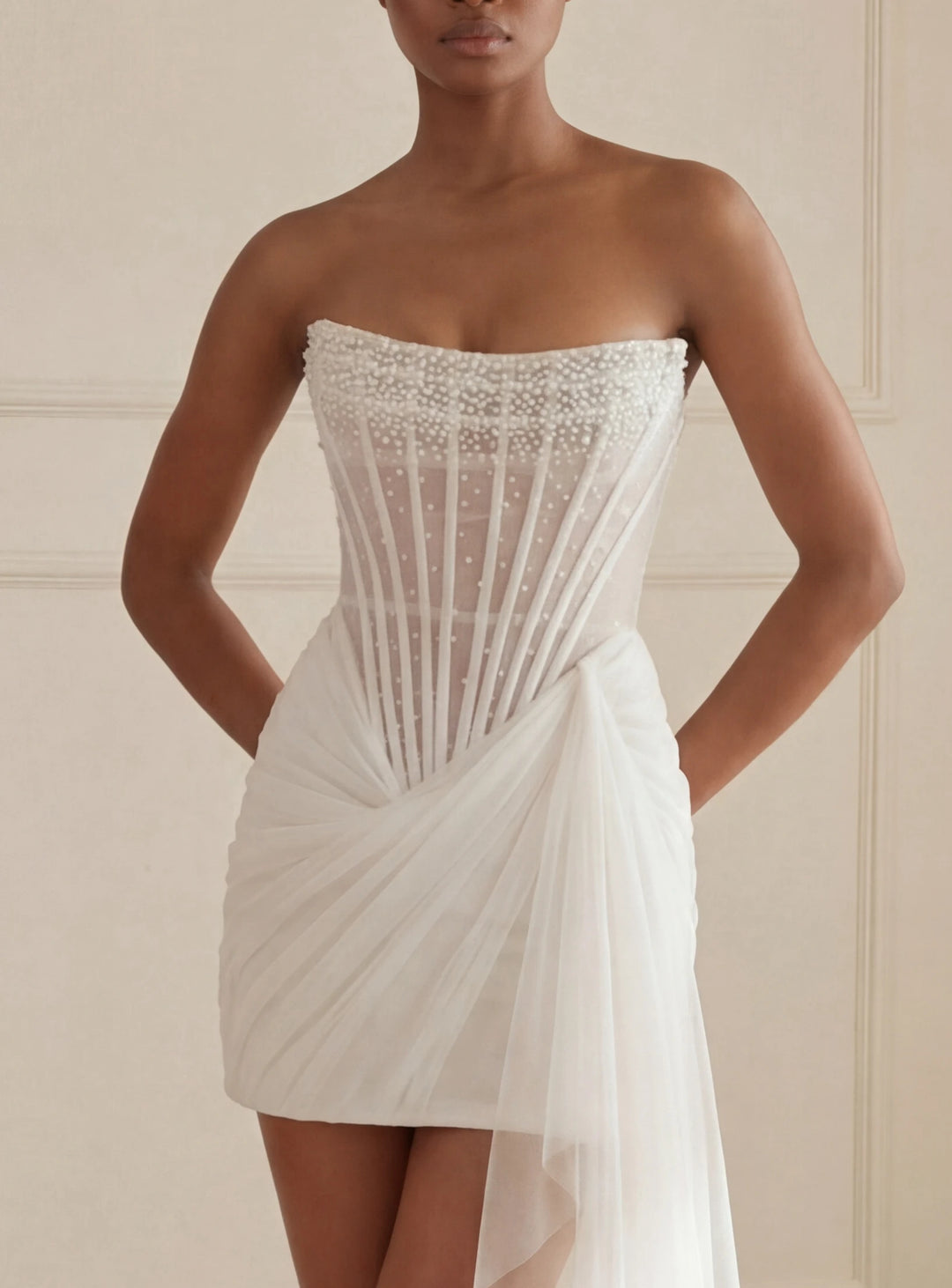 White strapless dress with intricate detailing on a neutral background