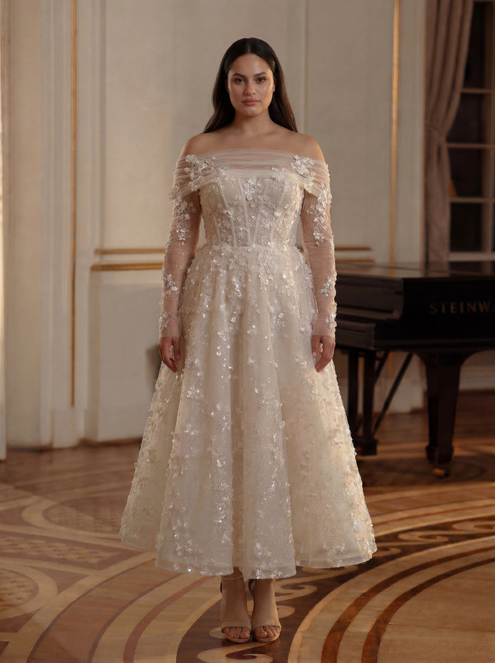 Woman in a white off-shoulder dress standing in an elegant room with a piano.