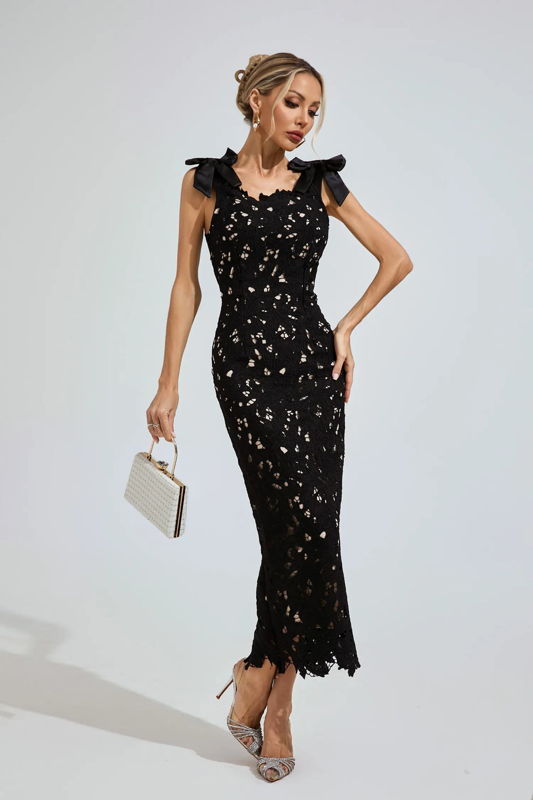 Woman wearing a black dress with floral details on a white background