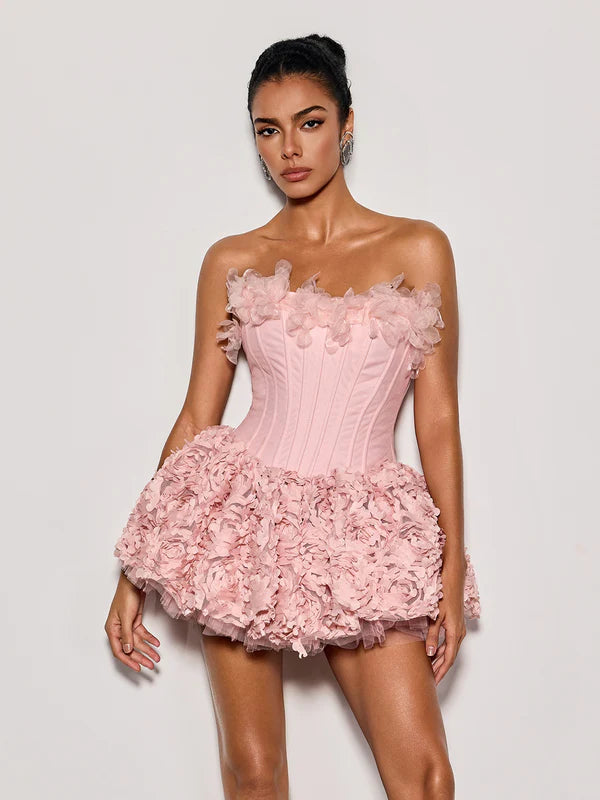 Woman wearing a pink floral dress against a plain background