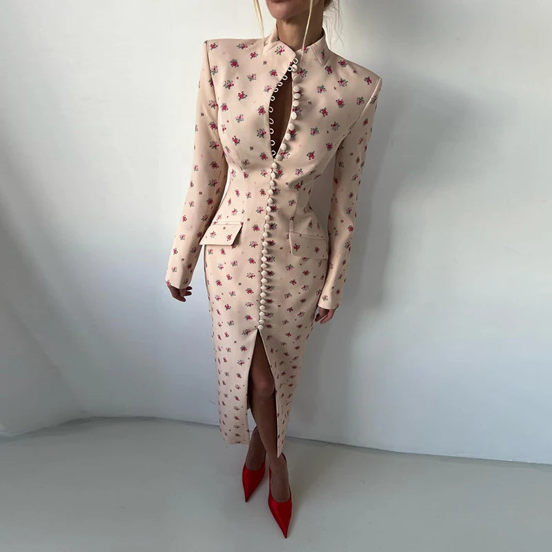 Woman wearing a floral dress with a high slit and red shoes on a white background
