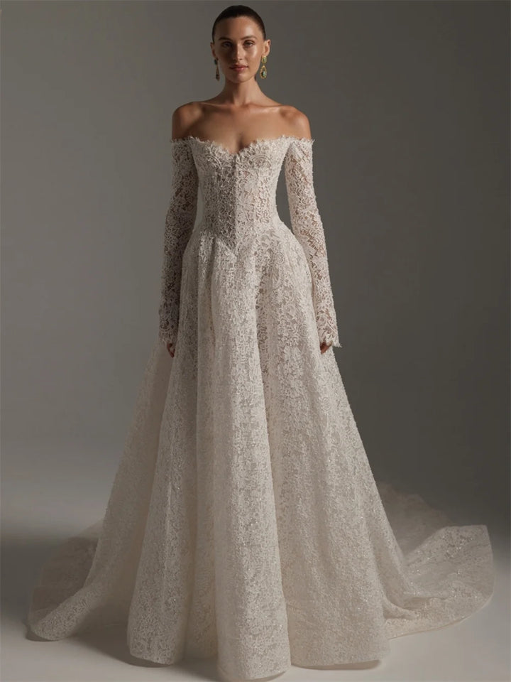 Woman wearing a white lace wedding dress against a gray background