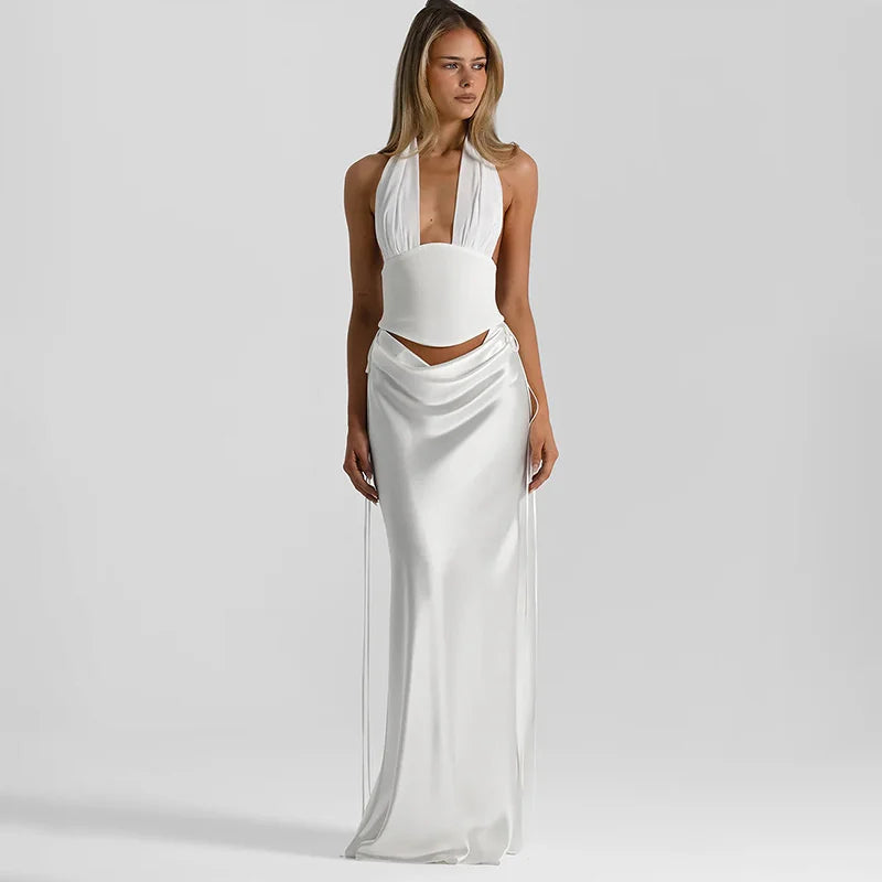 Woman wearing a white halter neck dress with a plain background