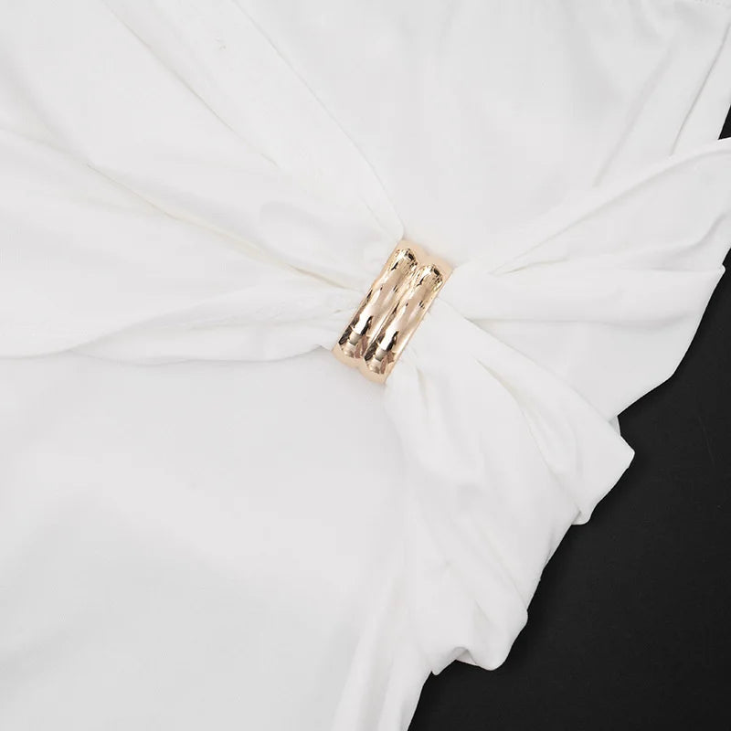 Close-up of a white garment with a gold tag on a black background