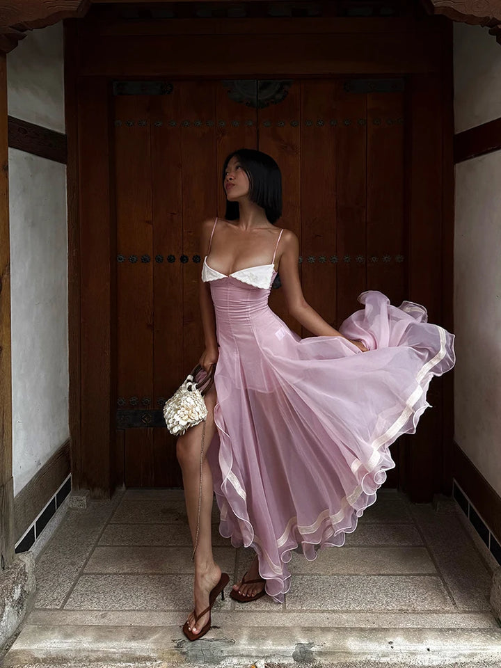 Woman in a pink dress standing in a traditional setting
