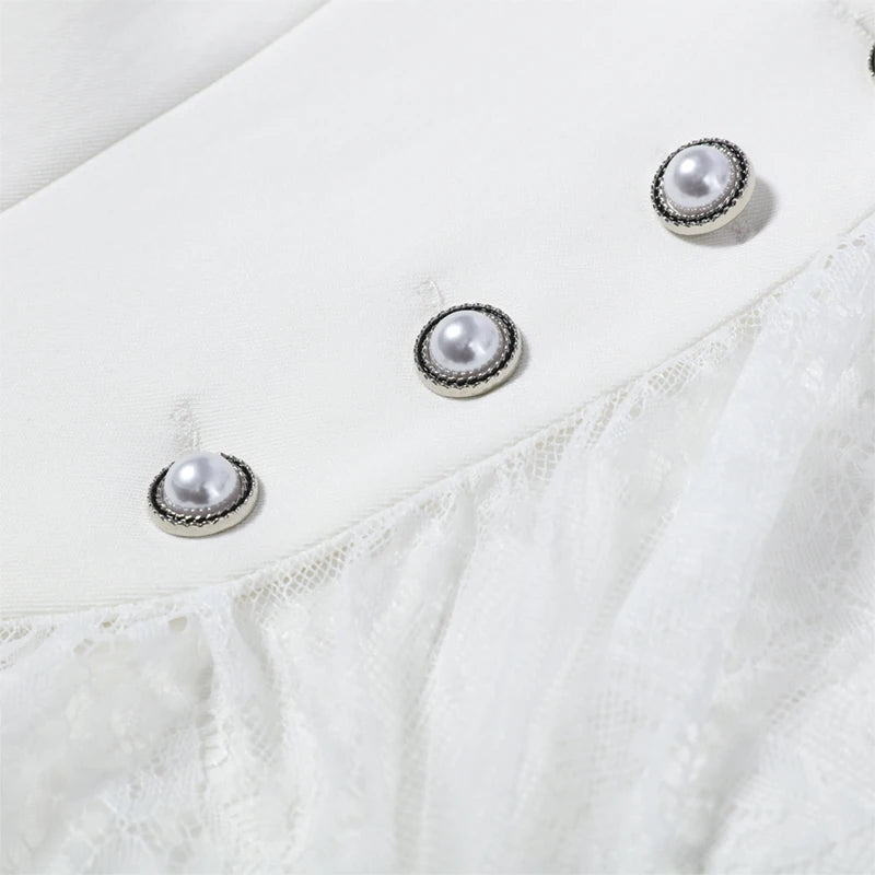 Close-up of a white garment with pearl-like button details on a light background