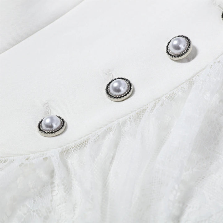 Close-up of a white garment with pearl-like button details on a light background