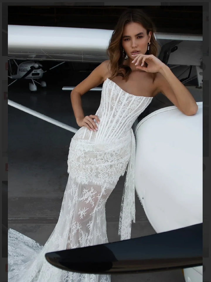 Woman in a white lace dress sitting on a white car with a private jet in the background