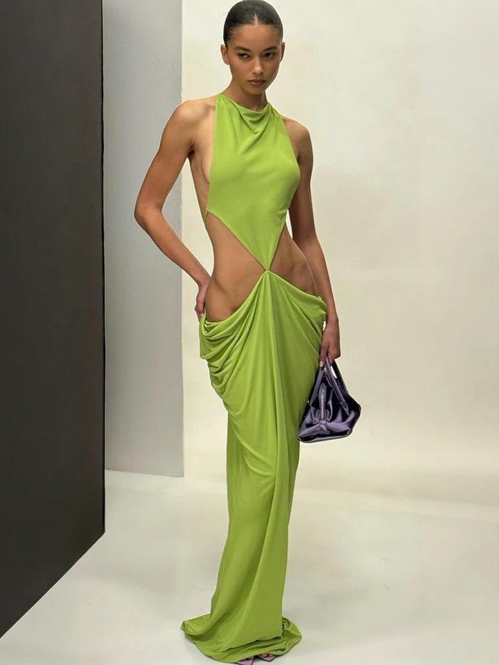 Model wearing a green evening gown with cut-out design on a plain background