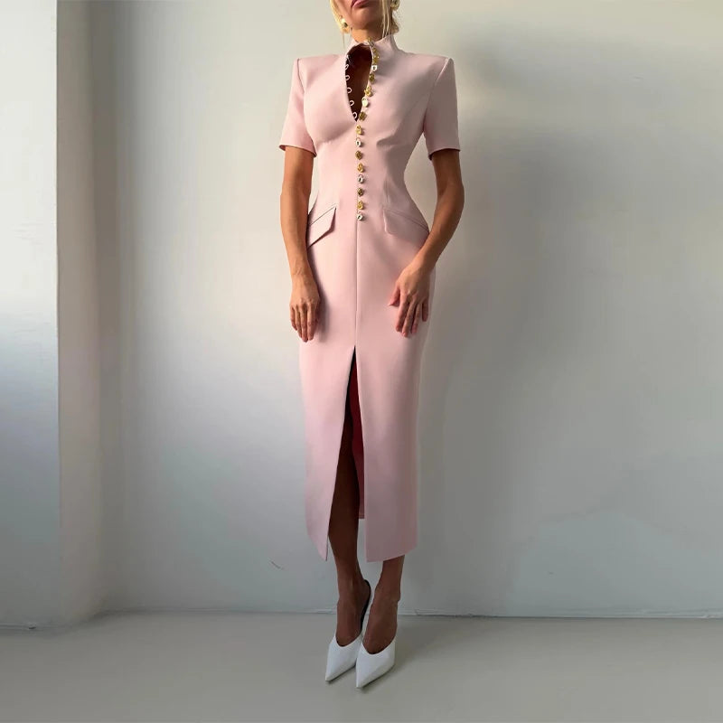 Person wearing a pink dress with a high slit on a plain background