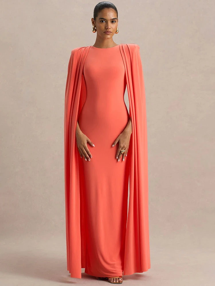 Woman wearing a coral evening gown with a draped design on a beige background