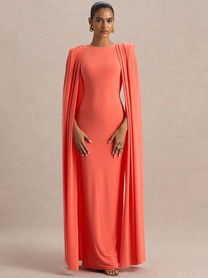 Woman wearing a coral evening gown with a draped design on a beige background