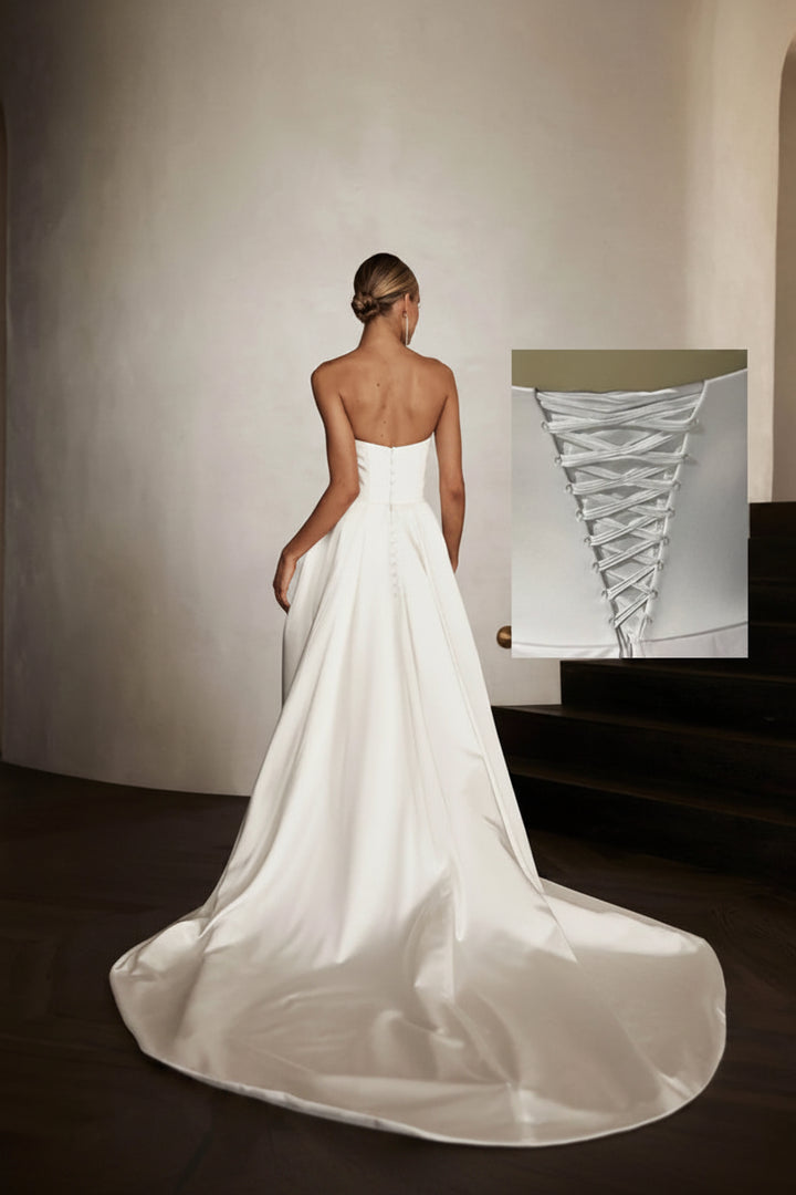 White wedding dress with a close-up inset of lace detail on a neutral background