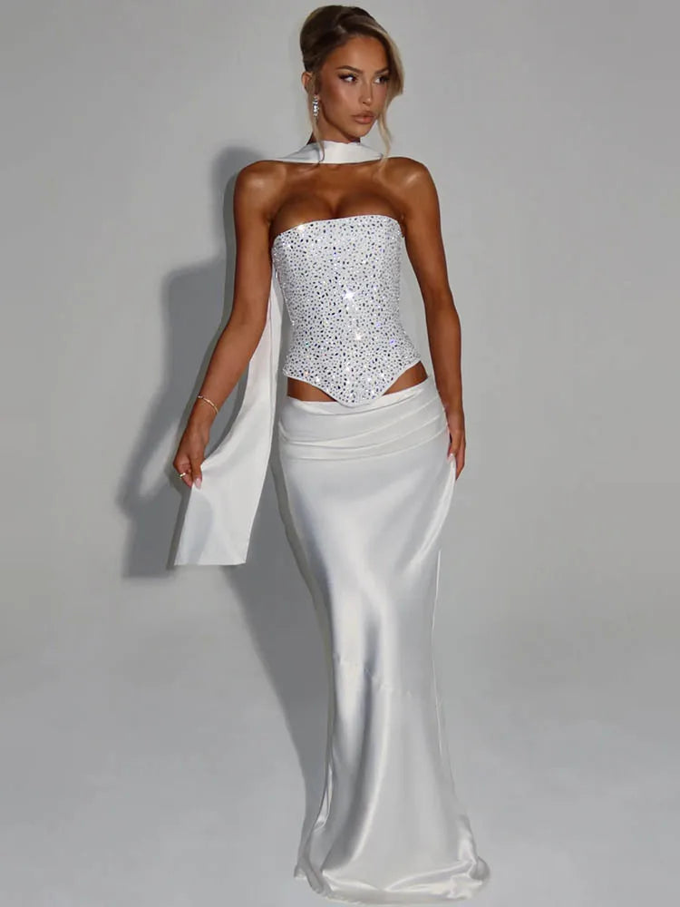 Woman wearing a white evening gown with a cutout design on a gray background