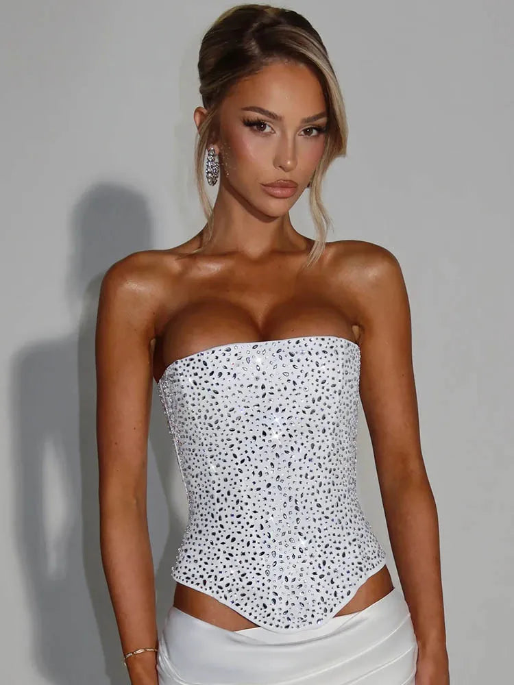 Woman wearing a white strapless top with black polka dots against a gray background