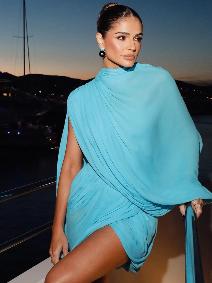 Woman in a blue dress on a boat at sunset