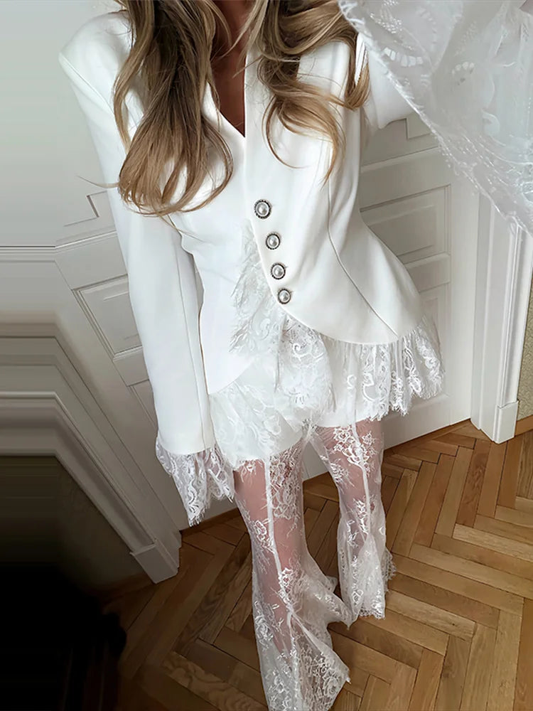 Person wearing a white lace outfit with a wooden floor and white wall in the background
