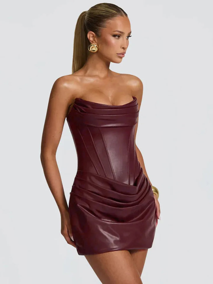 Woman wearing a strapless burgundy dress on a light gray background