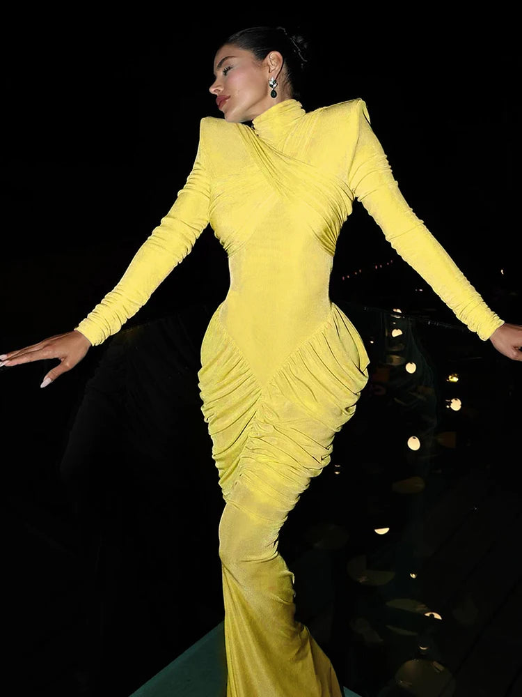 Woman in a yellow evening gown against a dark background