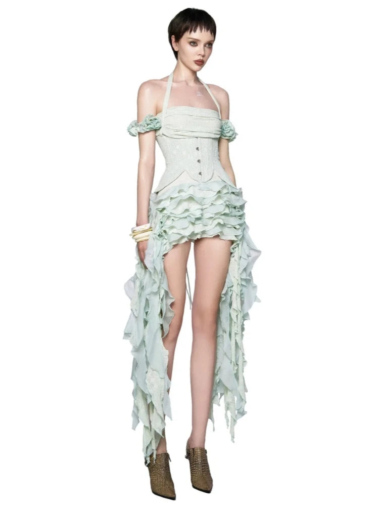 Model wearing a light green, ruffled dress with a white background