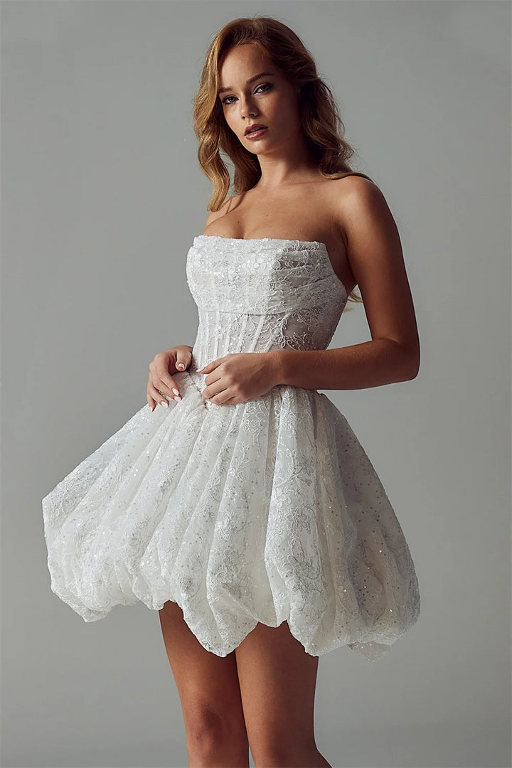 Woman wearing a white strapless dress against a gray background