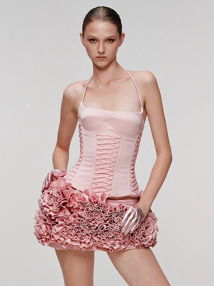 Model wearing a pink dress with floral details on a plain background